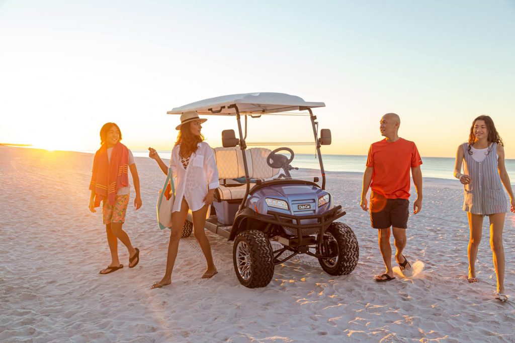 family in golf car at the beach. Club Car onward